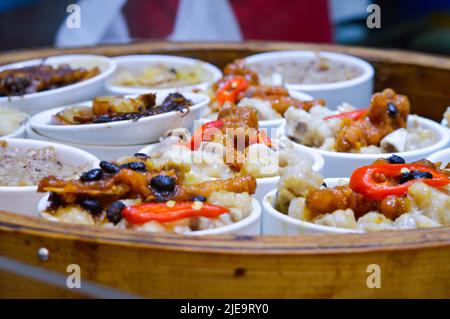 Close-up of Chinese steamed chicken feet in bamboo steamer at Hong Kong street market Stock Photo