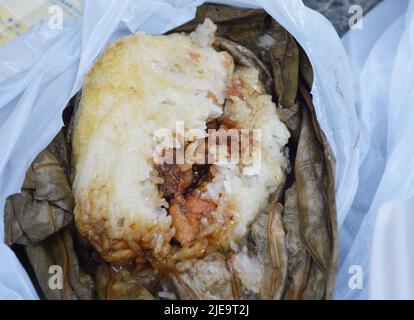 Famous Hong Kong dim sum 'Lo Mai Gai', the glutinous rice with meat and mushroom wrapped by lotus leaf. Stock Photo