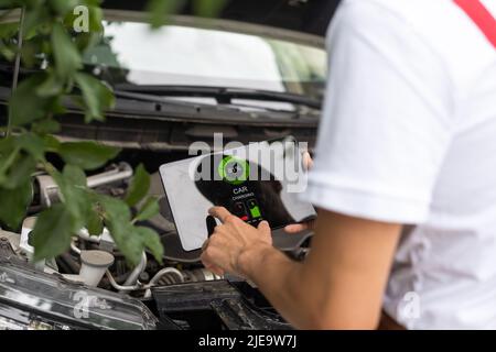 car service, repair, technology, maintenance and people concept - mechanic man with tablet pc computer making system diagnostic at workshop Stock Photo