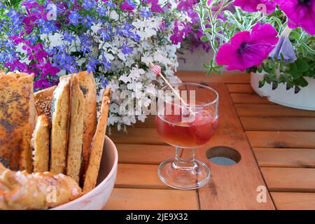 Sommerliche Erfrischung mit passenden Knabbereien, für den gemütlichen Abend auf Balkon und Terrasse Stock Photo