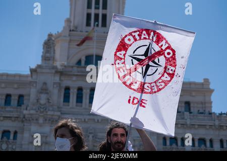 Madrid, Spain. 26th June, 2022. A protester holds a banner during a demonstration against NATO in Madrid Protest groups against NATO (North Atlantic Treaty Organization) and against war took to the streets of Madrid in a demonstration. This year Madrid is the venue for the NATO summit. Multiple groups from all over Spain and Europe traveled to participate in the demonstration. Credit: SOPA Images Limited/Alamy Live News Stock Photo