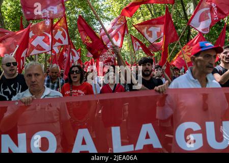 Madrid, Spain. 26th June, 2022. Protesters hold flags and a banner during a demonstration. Hundred of people took part in a demonstration against NATO summit that will take place in Madrid next week. (Photo by Guillermo Gutierrez/SOPA Image/Sipa USA) Credit: Sipa USA/Alamy Live News Stock Photo