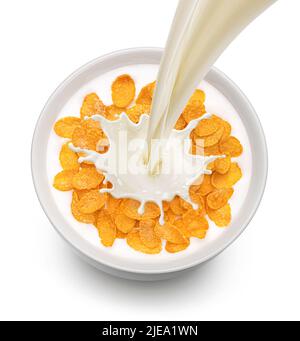 Corn flakes with pouring milk isolated on white background, top view Stock Photo