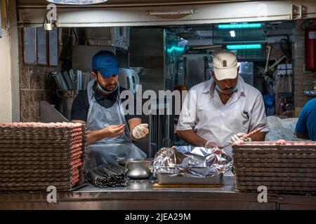 Two adult males making Kebabs at the Souq Al Mubarakeya Stock Photo
