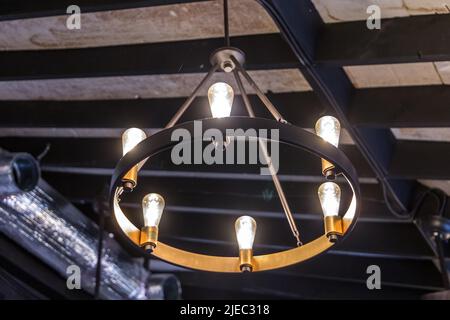 A rustic hanging mid-evil type light fixture or lantern hung from a high ceiling Stock Photo