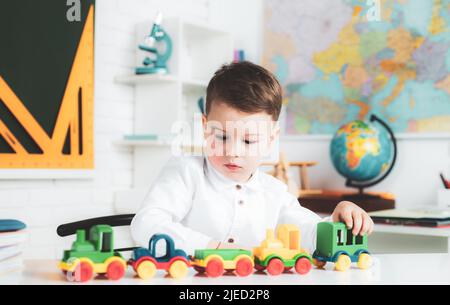 Home kids schooling. Child boy education concept. Cute pupil with funny face schooling work. Stock Photo