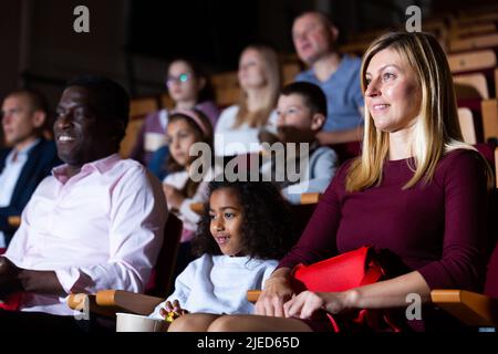 international family sitting at premiere in cinema Stock Photo