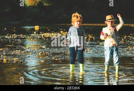 Skipping Stones on Water. Children in action of throwing stone or rock in water. Stock Photo