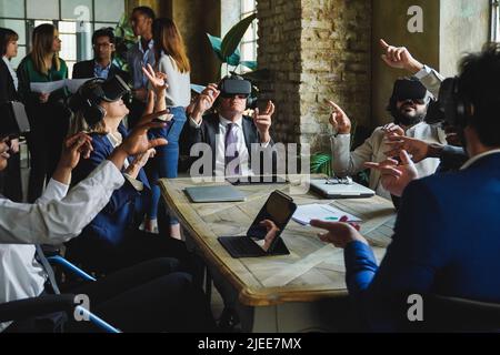 Diverse business people working with virtual reality headsets inside office - Focus on senior woman face Stock Photo