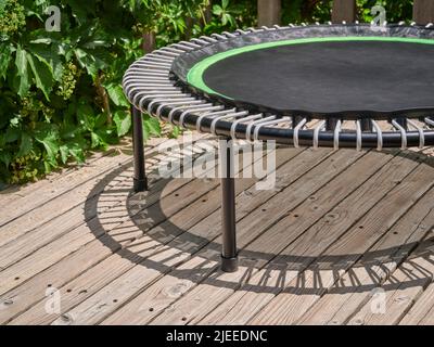 detail of mini trampoline for fitness exercising and rebounding in a backyard patio with shadow Stock Photo