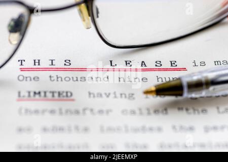 Close up of a lease for a property shown with eye glasses. A legal document for long term rental or ownership of a business premise or home. Stock Photo