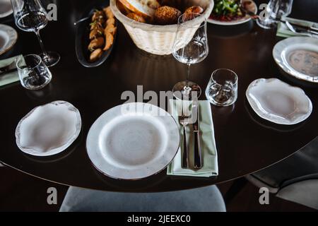 Beautifully organized event - round served table banquet ready for guests, round decorated table with empty plate, glasses, forks, napkin. Elegant dinner table  Stock Photo