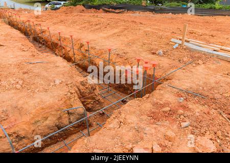 Building a house foundation by laying steel in a trench Stock Photo