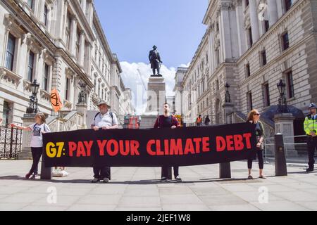 London, England, UK. 26th June, 2022. Extinction Rebellion activists hold a 'Pay your climate debt' banner next to the statue of Robert Clive in Westminster. The action was part of the day's protest and march demanding that the G7 cancels the debt of the countries in the Global South, which is forcing the nations to extract fossil fuels to pay off the debts. (Credit Image: © Vuk Valcic/ZUMA Press Wire) Stock Photo