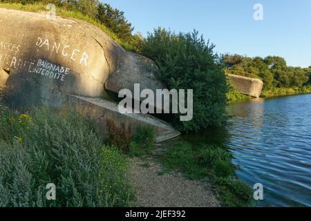 Sunken german bunker on lake le Fartz in golden sunlight at evening, Wissant, France Stock Photo