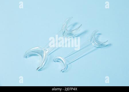 set of several Retractor Dental lip retractor Access to the oral cavity. Wide mouth opening for a dental procedure on a blue background Stock Photo