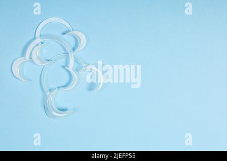 set of several Retractor Dental lip retractor Access to the oral cavity. Wide mouth opening for a dental procedure on a blue background Stock Photo