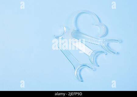 set of several Retractor Dental lip retractor Access to the oral cavity. Wide mouth opening for a dental procedure on a blue background Stock Photo