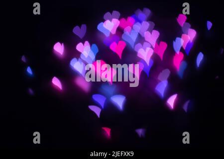 Abstract beautiful blurred violet-purple-lilac and pink colored of swirling heart shaped bokeh from ornamental lights flickering in the park. Backgrou Stock Photo