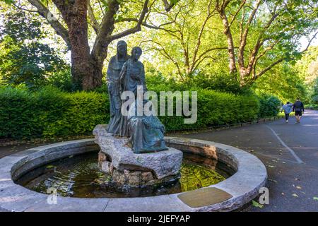 Dublin, Ireland - June 3, 2022: A fountain in St Stephen's Green Park with a sculpture, a portrait of three women. Stock Photo