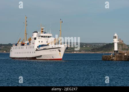 Penzance Harbour, Cornwall, England, UK. 2022.  Passenger ferry passing harbour light. as she arrives into Penzance, Cornwall having sailed from St Ma Stock Photo