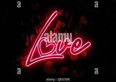 Love Neon Sign on a Dark red heart decorated Wooden Wall 3D illustration. Stock Photo