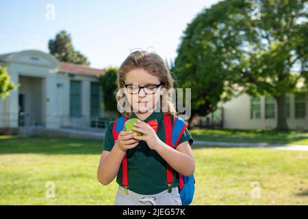 Schoolboy eating tasty aplle lunch outdoors school. Stock Photo