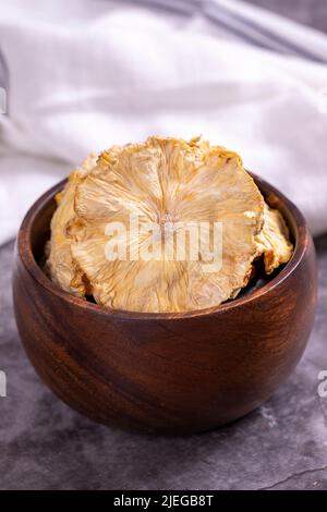 Dried pineapple slices. Sliced dried pineapple on dark background. Sun-dried fruit. close up Stock Photo
