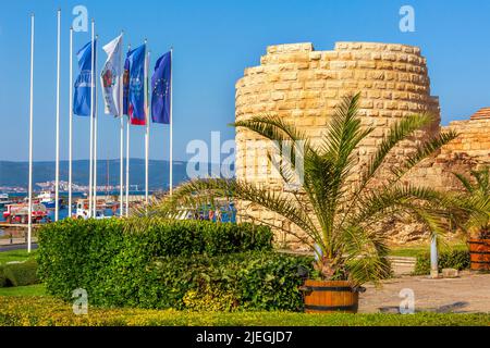 Nesebar, Bulgaria - July 25, 2016: Stone old wall and flags at the entrance of old town Nessebar, Black sea bulgarian resort Stock Photo