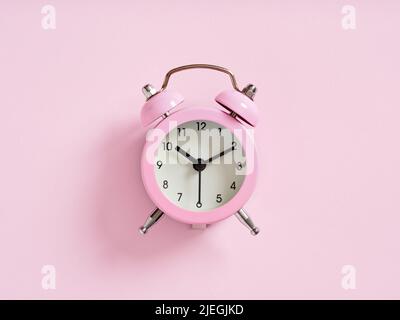 Pink alarm clock on pink background. Close up macro view. Stock Photo