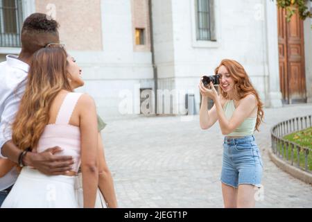 Cropped photo of a woman taking a photo to a group of friends embraced together outdoors Stock Photo