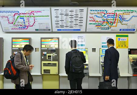 Customers buying train tickets at automated ticket machines, TokyoJP Stock Photo