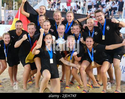 Heraklion, Greece. 26th June, 2022. Beach handball, World Cup: Germany's beach handball players around captain Lucie-Marie Kretzschmar (front 4th from left) cheer after the historic World Cup triumph. The team won 0:2 against Spain. A year after the European Championship victory, the beach women won the next big title and promoted the sport, which is overshadowed by indoor handball. (to dpa 'Jubilation over milestone: Beach women's handball team wins first World Cup gold') Credit: Julia Nikoleit/dpa/Alamy Live News Stock Photo