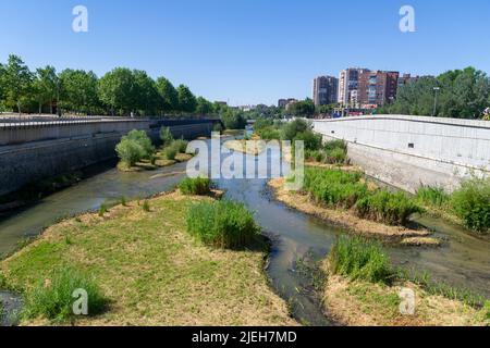 Madrid Rio Park. Views of the Madrid Río park next to the Manzanares river and green vegetation around it. Roads with bridges and footbridges. Stock Photo