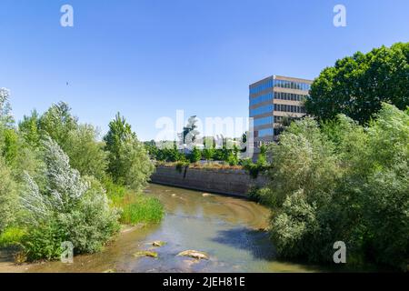 Madrid Rio Park. Views of the Madrid Río park next to the Manzanares river and green vegetation around it. Roads with bridges and footbridges. Stock Photo