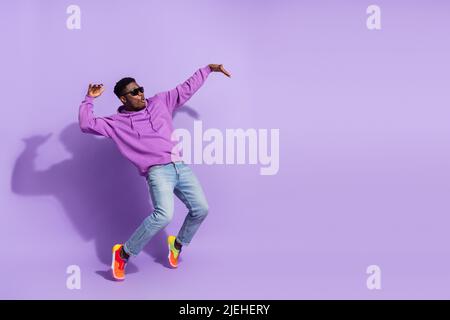 Full length profile photo of overjoyed carefree person stand tip toe dancing isolated on purple color background Stock Photo