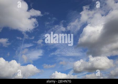 Beautiful blue clear summer sky natural background, fair summer weather white fluffy cumulus clouds, cirrus cloud in center Stock Photo