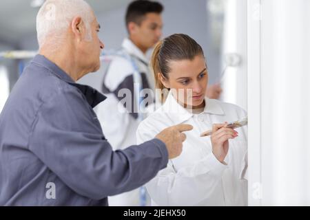 painter with apprentice and client Stock Photo