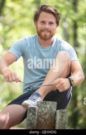 young athletic man jogger tying shoe laces Stock Photo