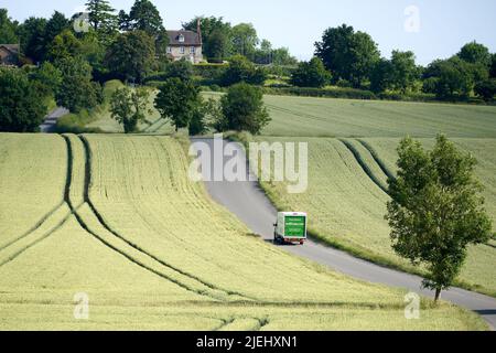 A Waitrose home delivery van makes it's way through the countryside to a make an online supermarket delivery at a customers home Stock Photo