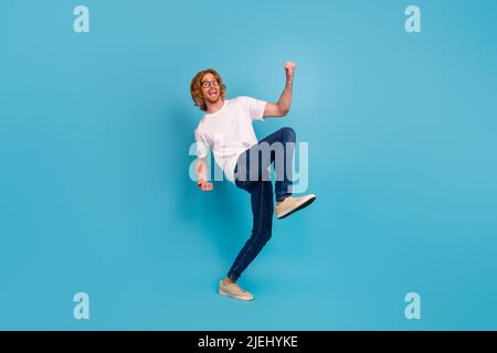 Full body portrait of delighted astonished person raise fists achievement isolated on blue color background Stock Photo