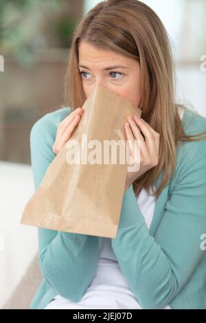 https://l450v.alamy.com/450v/2jej07d/breathless-woman-at-home-breathing-into-a-paper-bag-2jej07d.jpg