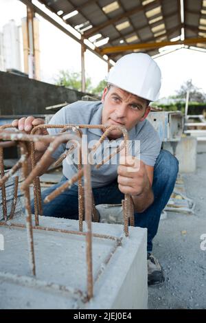 construction worker checking cement in factory floor Stock Photo