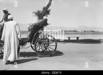Egypt Luxor Upper Egypt Antiquities 1948 1940s B&W photos of Western tourists visiting historic sites Carriage waiting for tourists along the Nile river Stock Photo