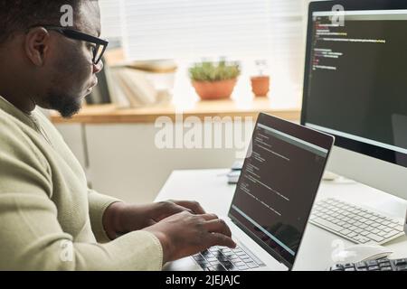 Programmer typing data code while working on project in software development company Stock Photo