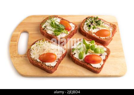 Red beet bread sandwiches with cream cheese, tomatoes and microgreen isolated on white background. side view, close up. Stock Photo