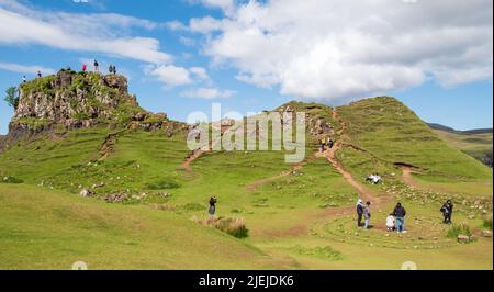 Tourists at Fairy Glen on Trotternish Peninsula. Varied landscape with hills, valleys and basalt cliffs in  north of Skye. Area suffers overtourism. Stock Photo