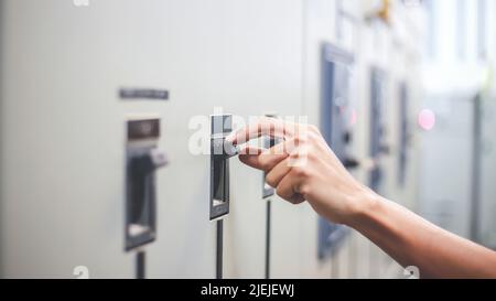 Engineers working to inspect and maintain electrical control cabinets. Stock Photo