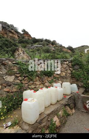 Big plastic bottles next a spring in the mountains Stock Photo