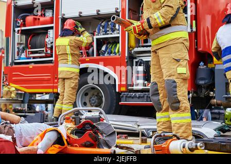 Rescuers provide first aid to the human dummy victim during rescue operation exercises Stock Photo